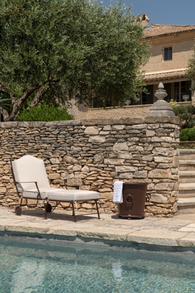 Hervé Baume wrought-iron sun lounger with garden accessories.