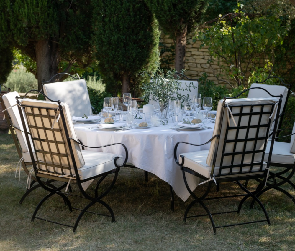 Table de jardin dressée entourée de fauteuils en fer forgé Hervé Baume, collection HB1 Quadrillage