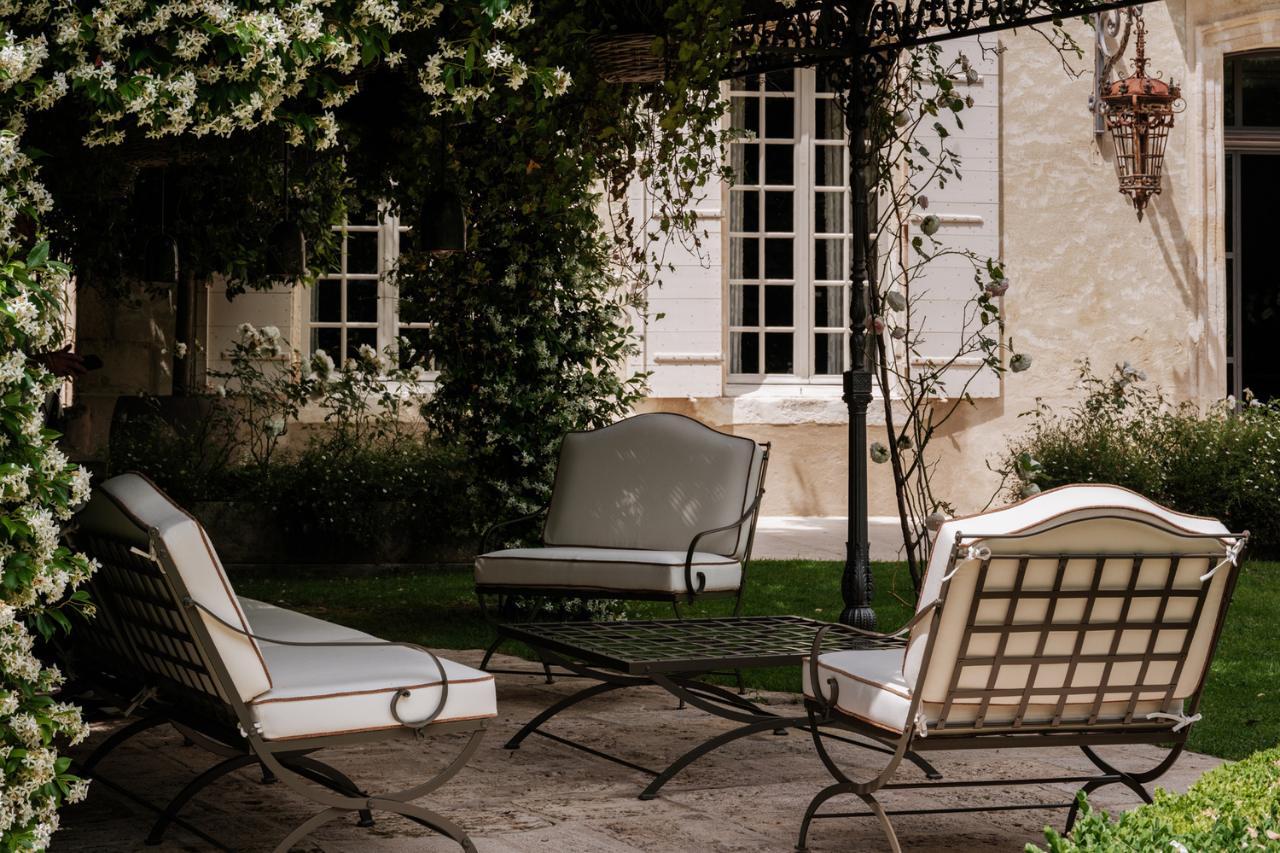 Hervé Baume HB12 Quadrillage Collection wrought-iron outdoor lounge furniture beneath a jasmine-covered pergola, Mas de Chabran.